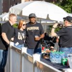 3 Purdue alumni posing for a picture being taken by another Purdue alumni