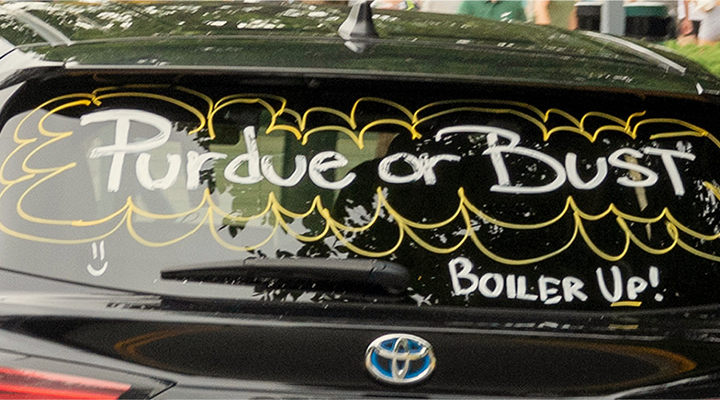 Purdue for Bust Boiler Up written on the back windshield of a car
