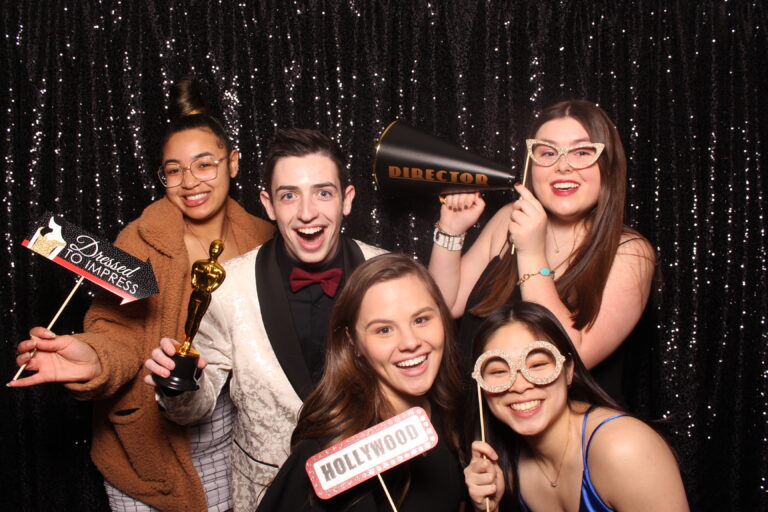 A group of people posing with props in a photo booth