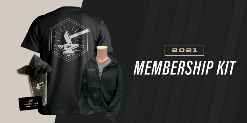 On left, different items for display. Black t-shirt with hammer and anvil on front. A drinking glass with hammer and anvil. A metal name tag. Also a jacket on a mannequin. Right side: 2021- Membership Kit