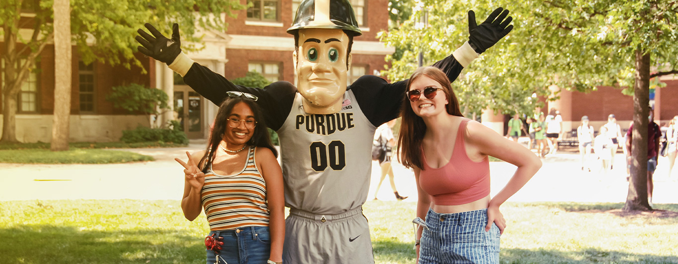 An image of two students posing with Purdue Pete