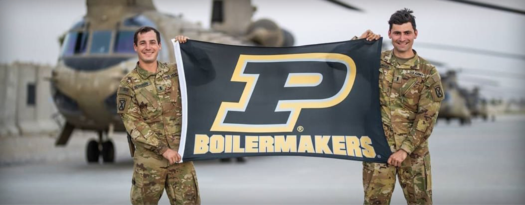 Two ROTC members holding Purdue flag