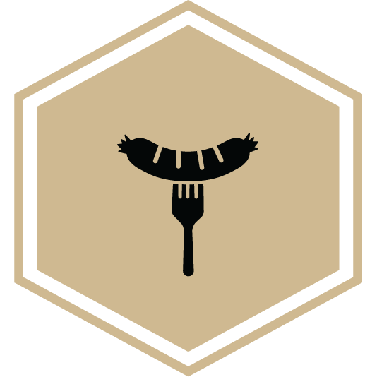 Hexagon icon showing for the Boilermaker Butcher Block field trip, featuring a sausage on a fork.