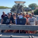 Group of Alumni posing in a airboat.