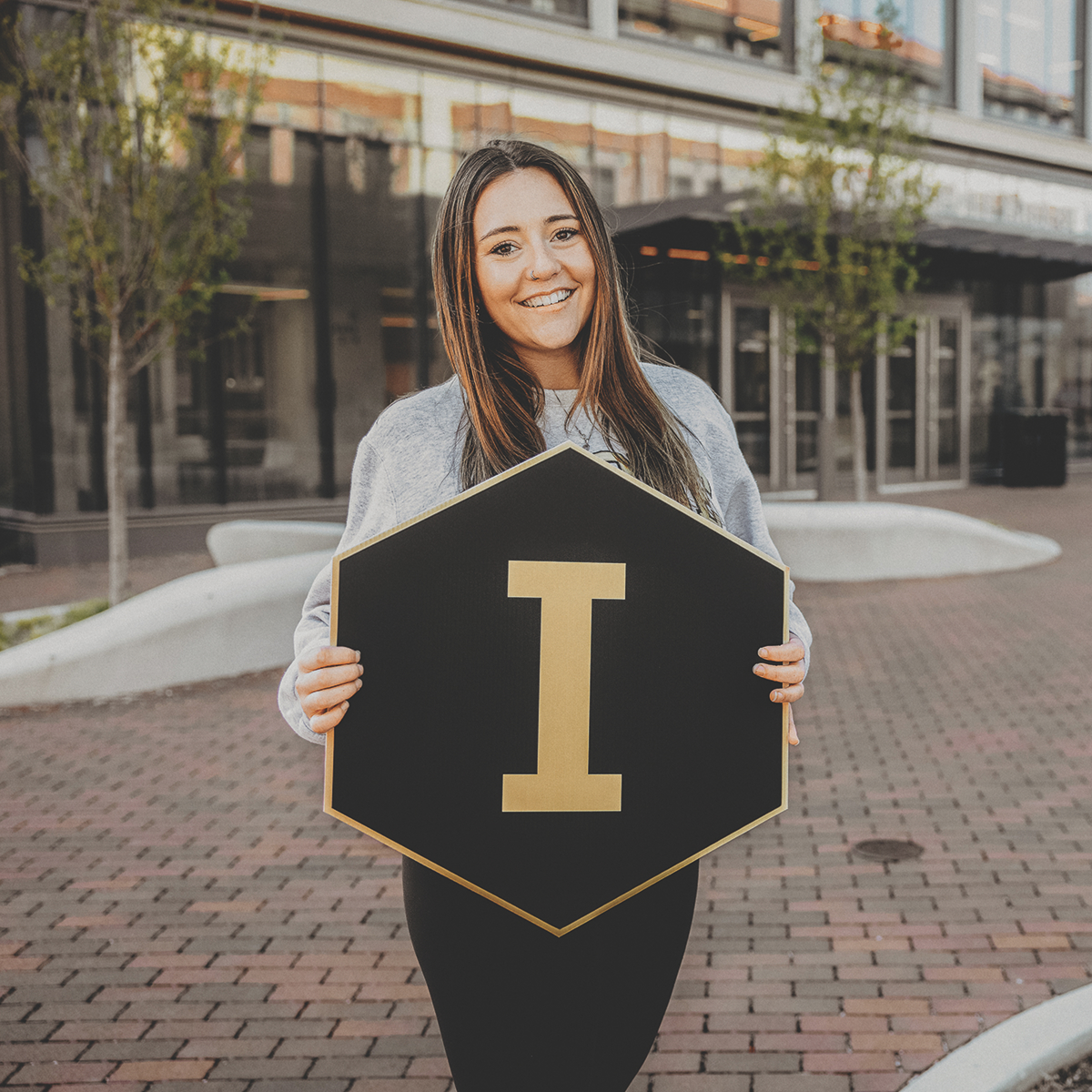 Student holding a "I" hexagon sign