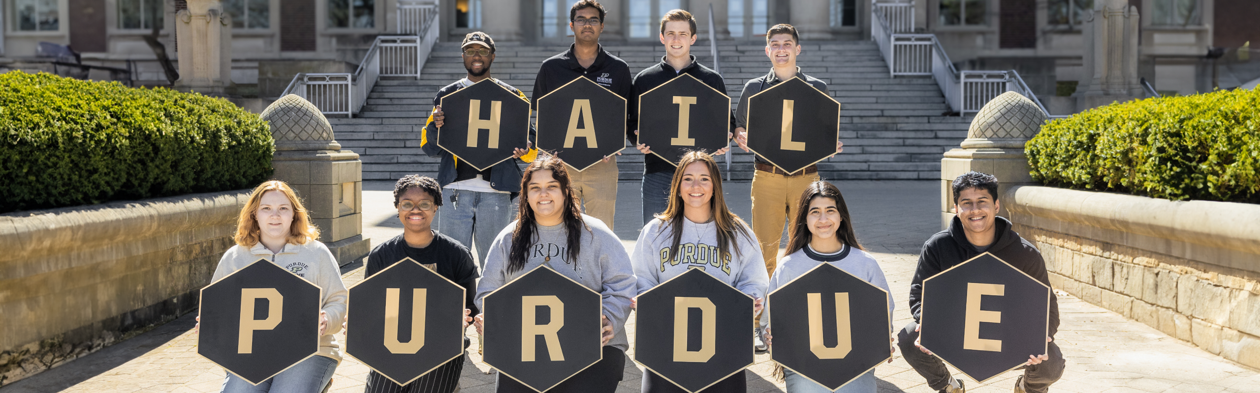 Purdue Students holding signs in front of Hovde Hall that spell out "Hail Purdue"