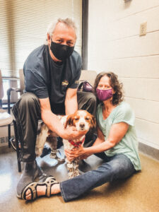 An image showing two adults and their pet friend Izzie at Purdue University.