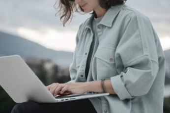 Image featuring an individual typing on her computer.