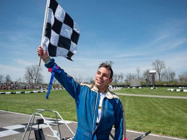 65th Annual Purdue Grand Prix race winner Kardashian holding up the checkered flag in celebration