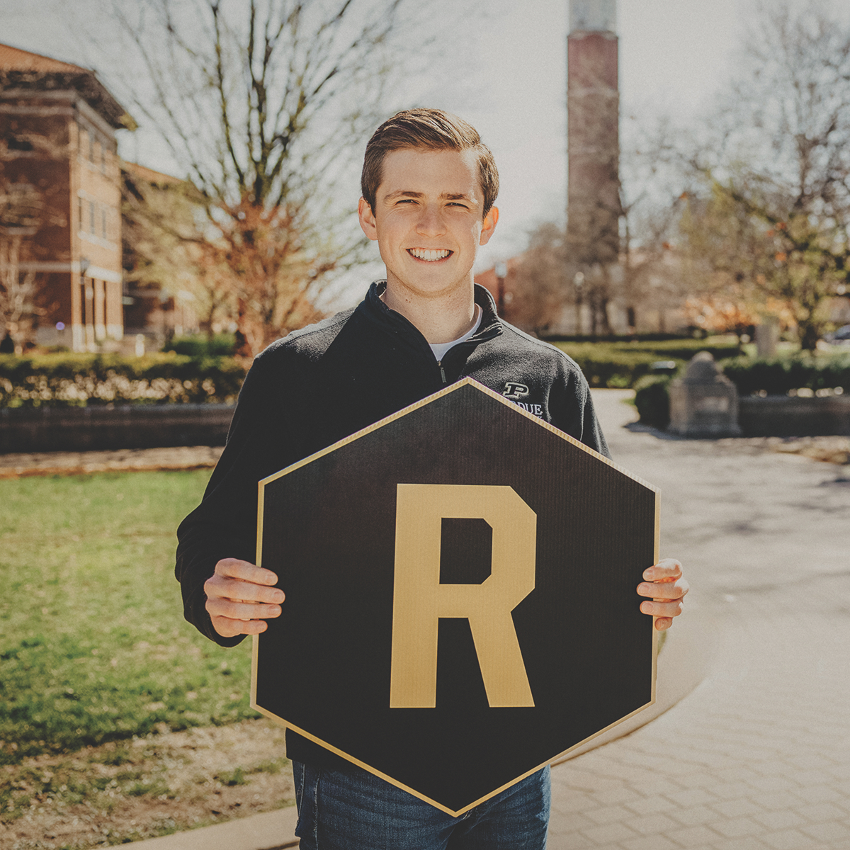 Student holding a "R" hexagon sign