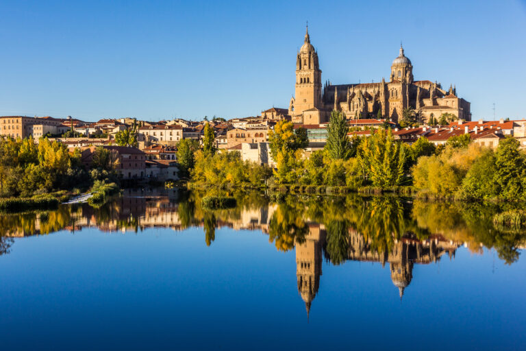 Cityscape of Salamanca and its mirror image on Tormes river (Spain).