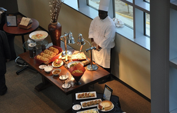 A table with food sitting on top of it with a chef standing behind it