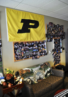 A empty couch with a Purdue flag hanging above it