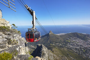Aerial cable car descending down on cables from top of mountain