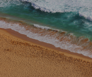 A beach with rolling waves up on the sand