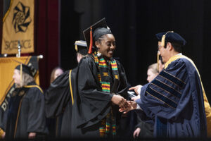 Purdue President Mung Chiang presents a diploma during spring commencement ceremonies.