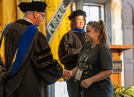 A kid receiving their GPU diploma from Purdue for Life Foundation's CEO Matt Folk