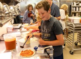 A kid cooking a pizza at a GPU event