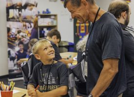 A child smiling up at his grandpa at a GPU event