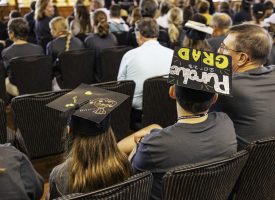 A crowd of people waiting to receive their GPU diploma