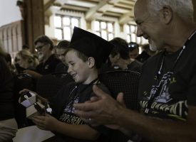 A child holding a paper Purdue Pete with his grandpa at GPU graduation