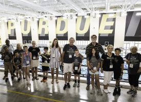 A group of kids with their grandparents standing in front of Purdue's pool