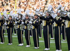 The image shows the All-American Marching Band during the Homecoming game.