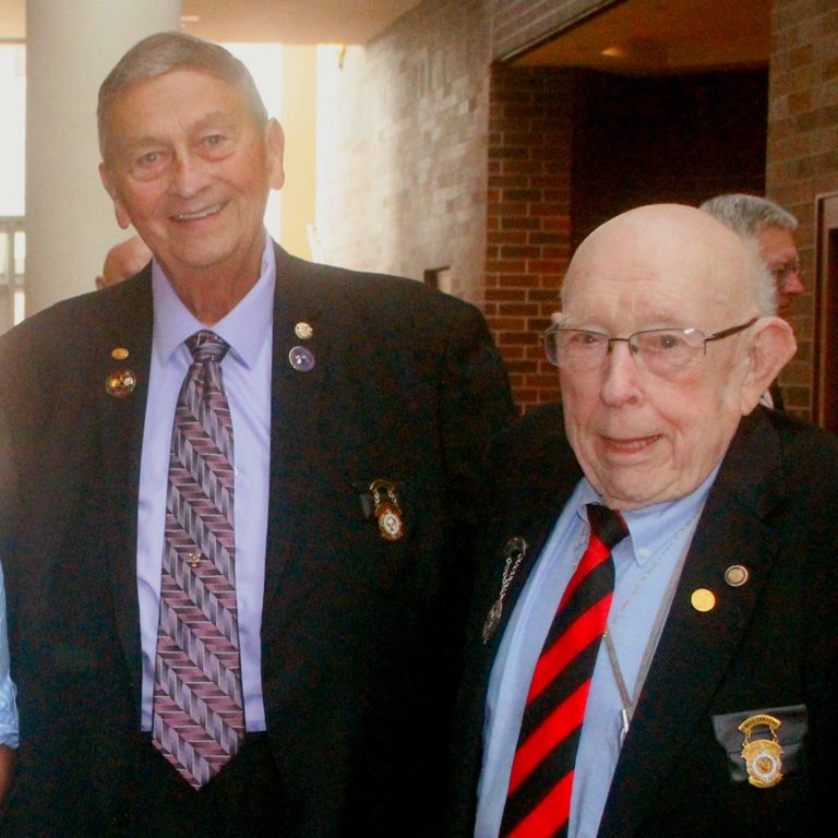 2 men standing next to each other smiling