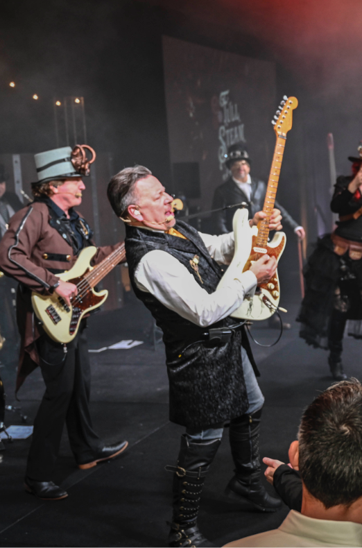 2 men playing guitar in steampunk outfits