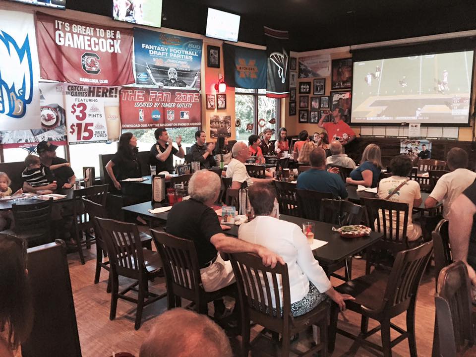 A group of Purdue Alumni watching a Purdue Football game in a restaurant