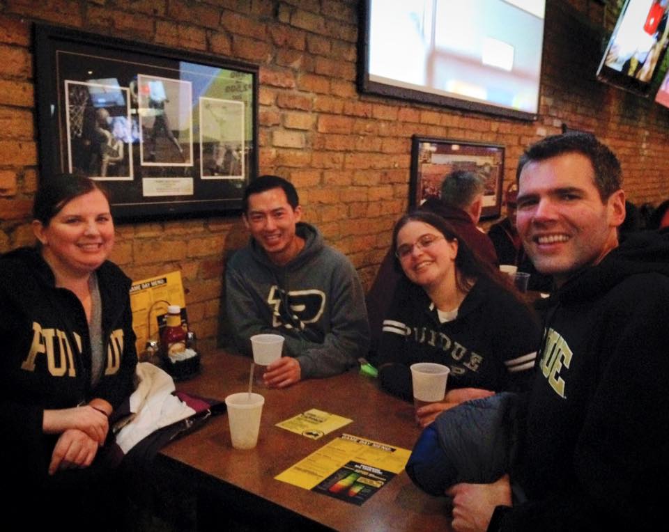 2 men and 2 women wearing Purdue merchandise posing for a photo
